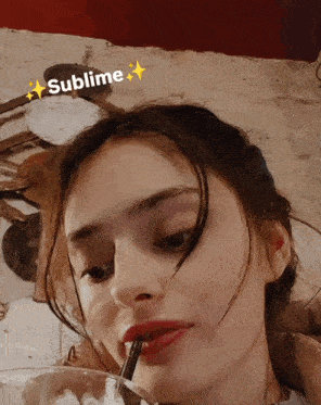 a woman with a straw in her mouth has the word sublime above her head