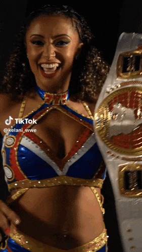 a woman in a wrestling outfit is smiling and holding a belt that says wwe on it