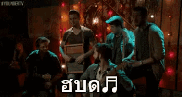 a group of men are dancing in a dark room with a sign that says youngertv on it