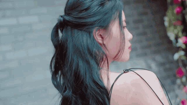 a woman with dark blue hair is looking over her shoulder