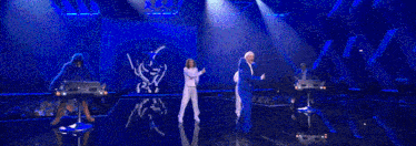 a man in a blue suit stands on a stage