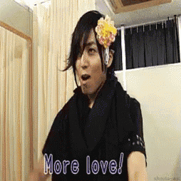 a man with a flower in his hair is saying more love .