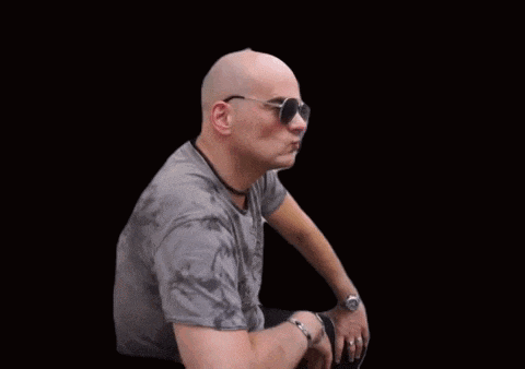 a bald man wearing sunglasses and a gray shirt