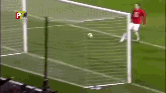 a soccer player in a red shirt with the number 20 on it kicks the ball into the goal