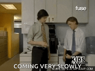 two men are standing in a kitchen and the words coming very slowly are on the bottom