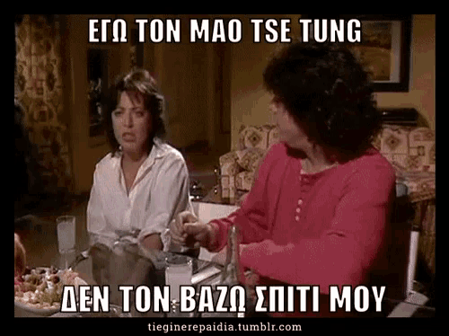 two women are sitting at a table with a caption in greek