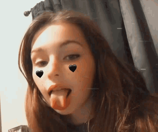 a young woman sticking her tongue out with hearts on her face