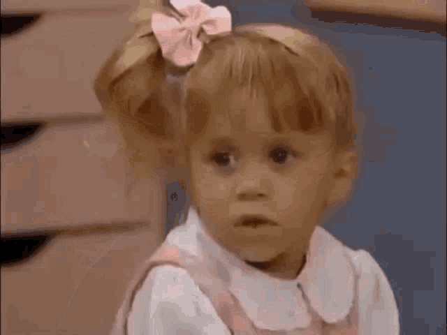 a little girl with a pink bow in her hair .