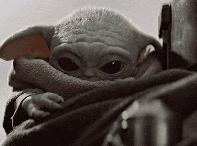 a close up of a baby yoda looking up