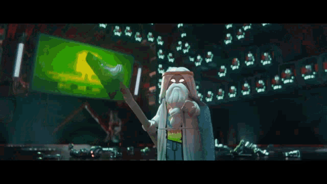 a lego figure is holding a clock in a room with a green screen behind it