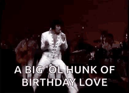 elvis presley is dancing on stage in front of a drum set and a crowd .