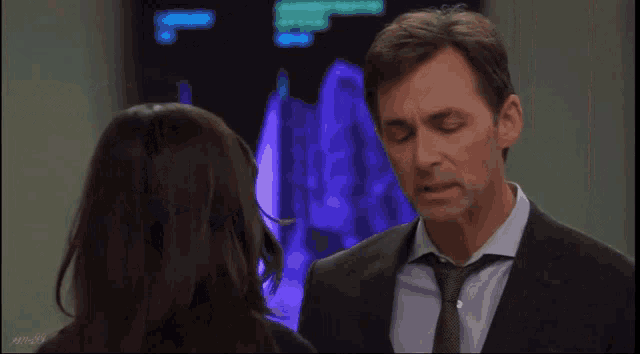a woman touches a man 's nose in an elevator with the number 1 on the wall behind them