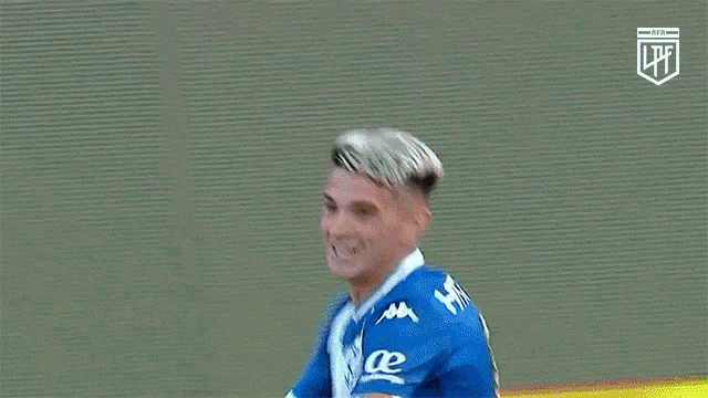 a soccer player wearing a blue shirt with kappa on the front is smiling .