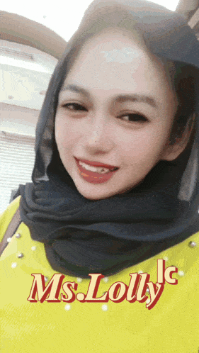 a woman wearing a black scarf and a yellow shirt with the name ms. lolly written on the bottom