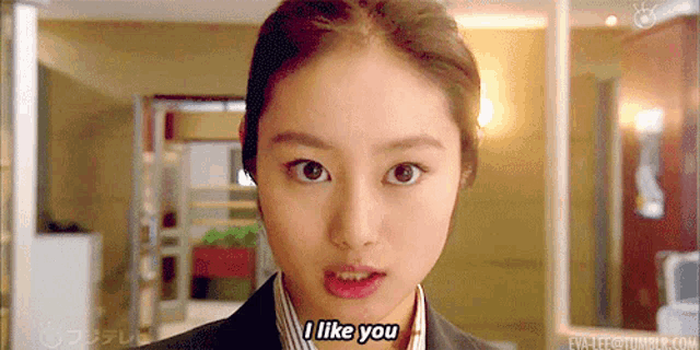 a woman in a suit says i like you in front of a mirror