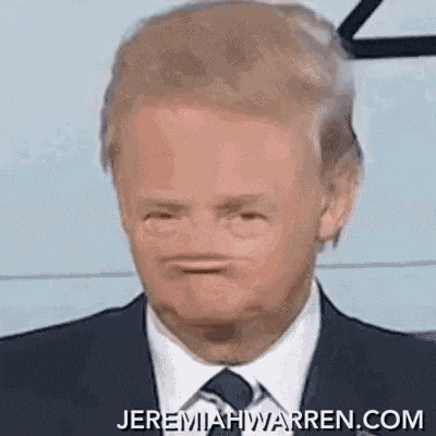 a man in a suit and tie is making a face with his mouth open .