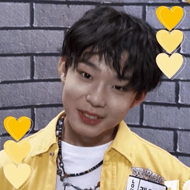 a young man wearing a yellow shirt is surrounded by yellow hearts