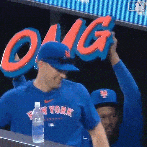 a man wearing a new york jersey holds up a sign that says omg