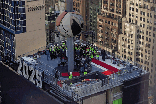 a group of people standing on top of a building with a sign that says ' 2024 ' on it