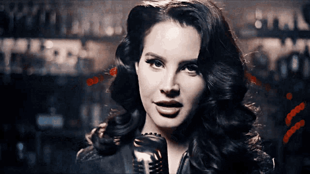 a woman is singing into a microphone with a blurry background