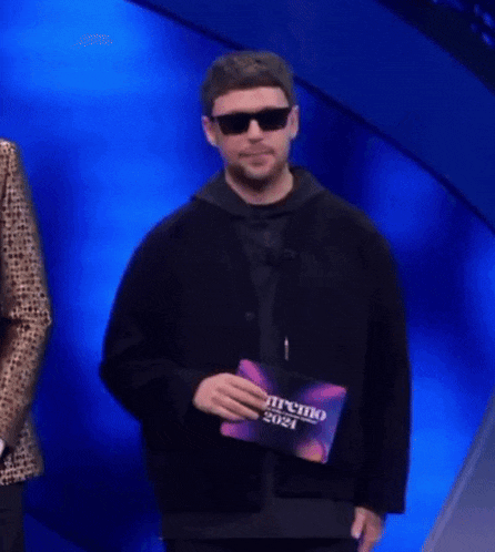 a man wearing sunglasses is holding a cd that says premio 2021