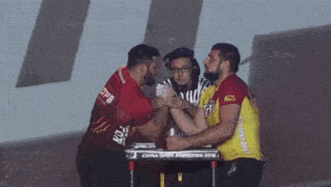 two men arm wrestling in front of a table that says china open shenzhen 2018 on it