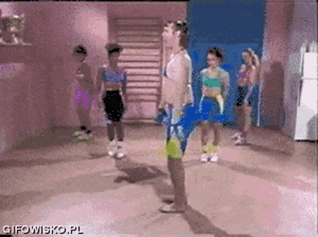 a group of people are dancing in a room with gifowisko.pl in the bottom right corner