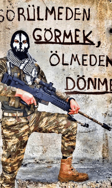 a soldier holding a gun in front of a wall that says " gormek " on it