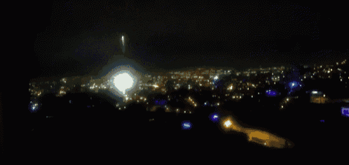 a fireworks display over a city at night with a blurry background