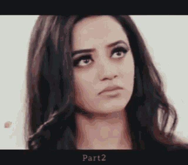 a woman with long dark hair is making a funny face .