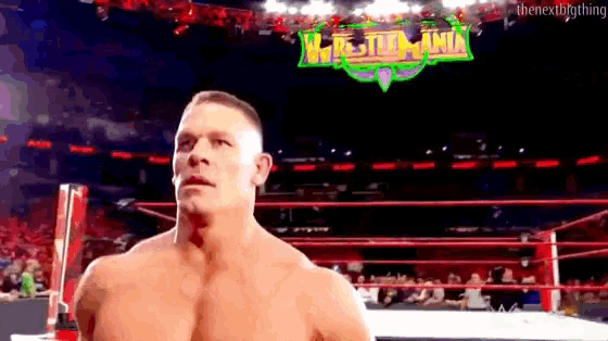 a man in a wrestling ring with a sign that says wrestlemania on it