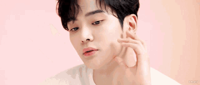 a close up of a young man 's face with a pink background and the word kpop on the bottom