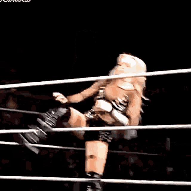 a woman is sitting in the middle of a wrestling ring .