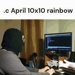 a person wearing a mask is typing on a keyboard in front of a computer monitor ..c april 10x10 rainbow