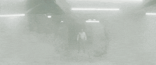 two men in suits and white shirts are walking in a room