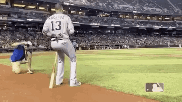 a baseball player with the number 13 on his jersey is standing on a baseball field .
