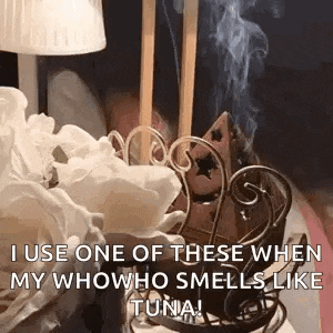 smoke is coming out of a incense burner on a table next to a lamp .