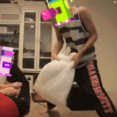 a man in a striped tank top is holding a white pillow while wearing a colorful mask