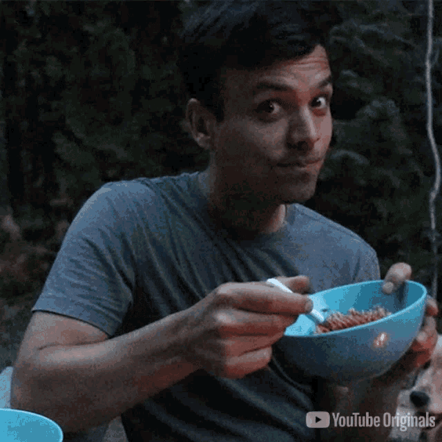 a man is eating from a bowl with a fork and a youtube originals logo in the corner