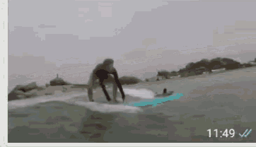a person riding a wave on a surfboard with the time 11:49 on the bottom