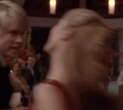 a man and a woman are dancing in a crowded room