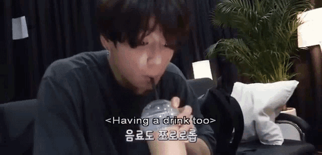 a man is drinking a drink through a straw .