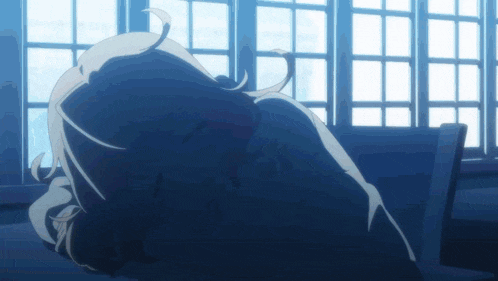a person laying down in front of a window with their head down