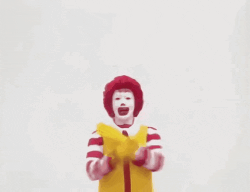 a mcdonald 's character with a red face and a yellow vest with a m on it
