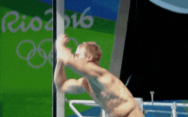 a shirtless man is jumping into a pool with rio 2016 in the background