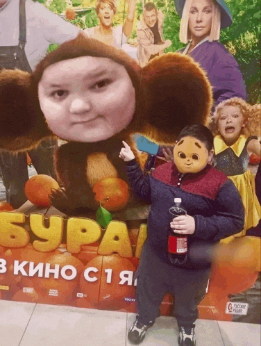 a child holding a coca cola bottle stands in front of a poster for a movie