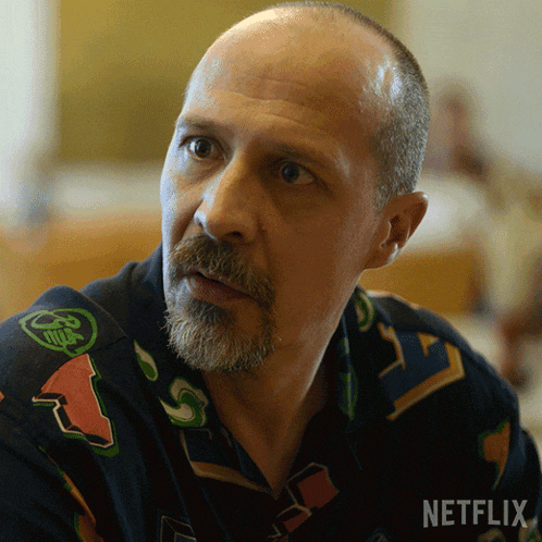 a bald man with a beard is wearing a shirt that says netflix on it