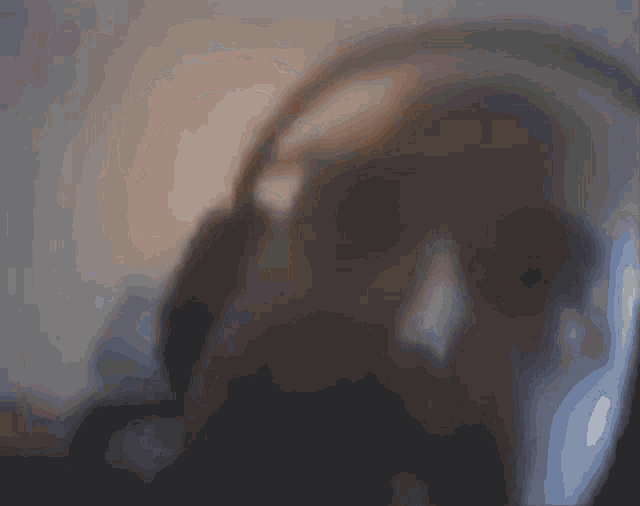a blurry picture of a man 's face with a purple and blue background