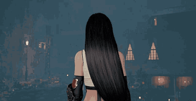 a woman with long black hair is standing in front of a dark building