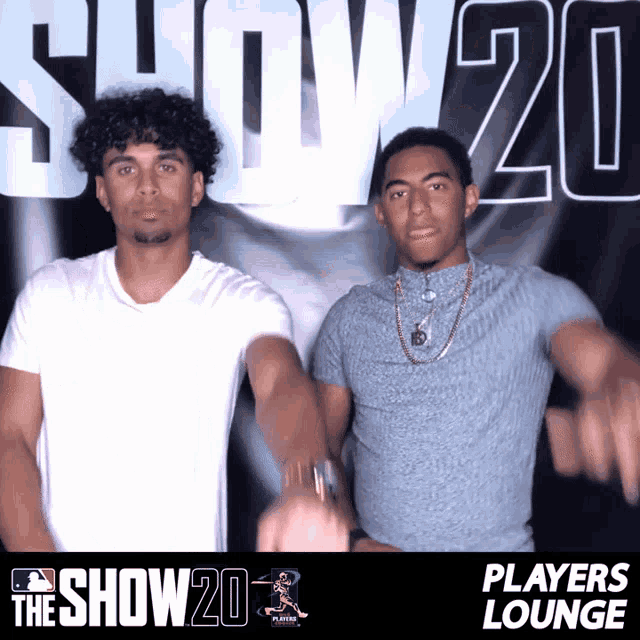 two men pose in front of a sign that says players lounge